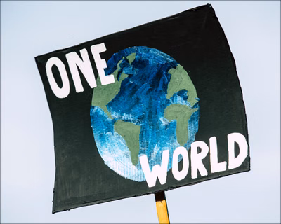 sign with painted globe and ONE WORLD copy on globe