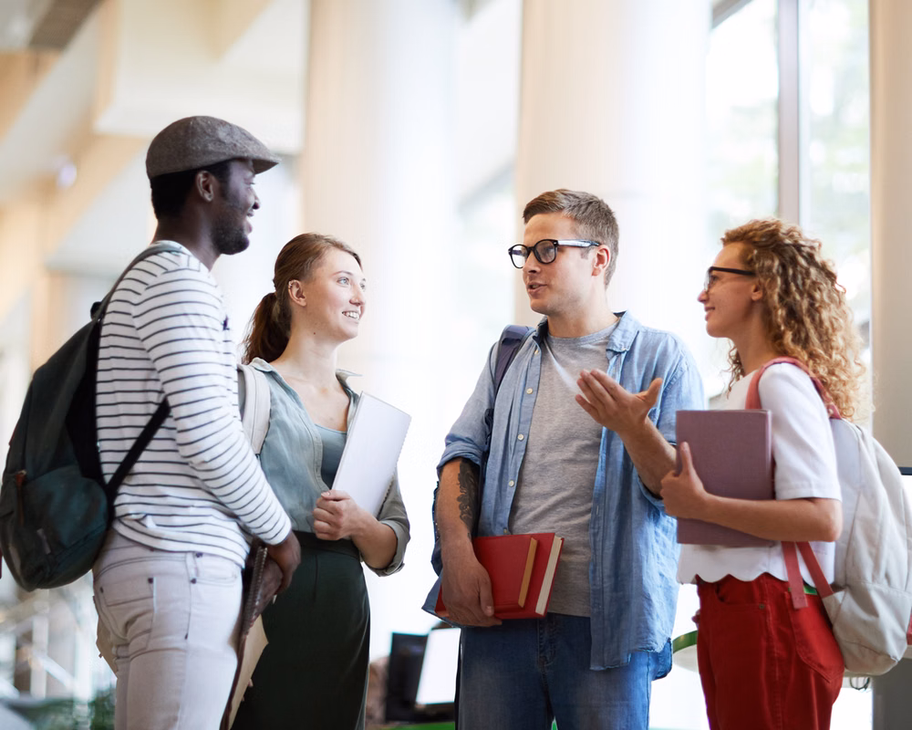 A diverse group of college students standing in a circle talking.