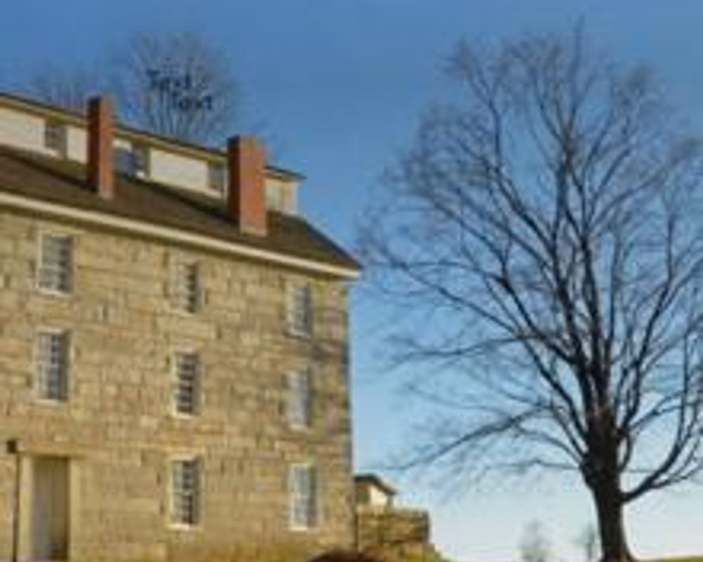 An old, three-story stone building on a sunny day
