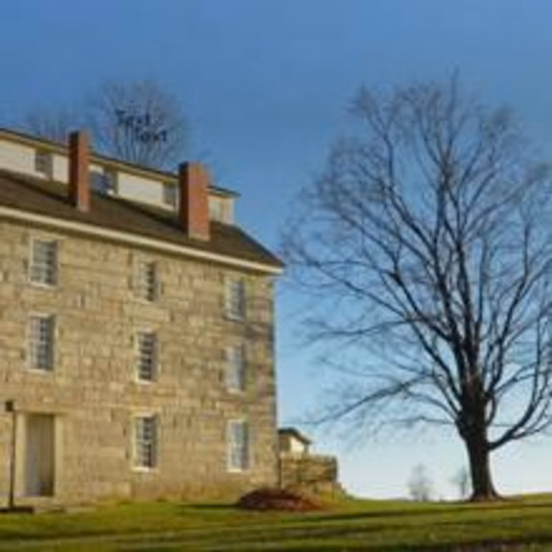An old, three-story stone building on a sunny day