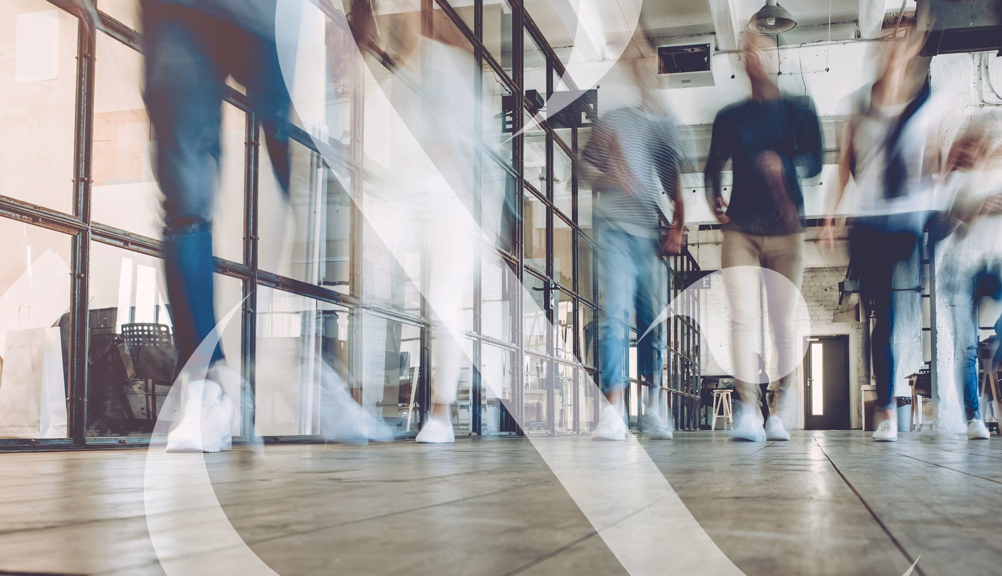An image taken at floor level showing students walking down a hallway, their motions blurred to show movement.