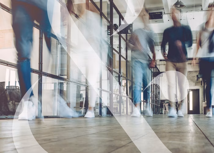 An image taken at floor level showing students walking down a hallway, their motions blurred to show movement.