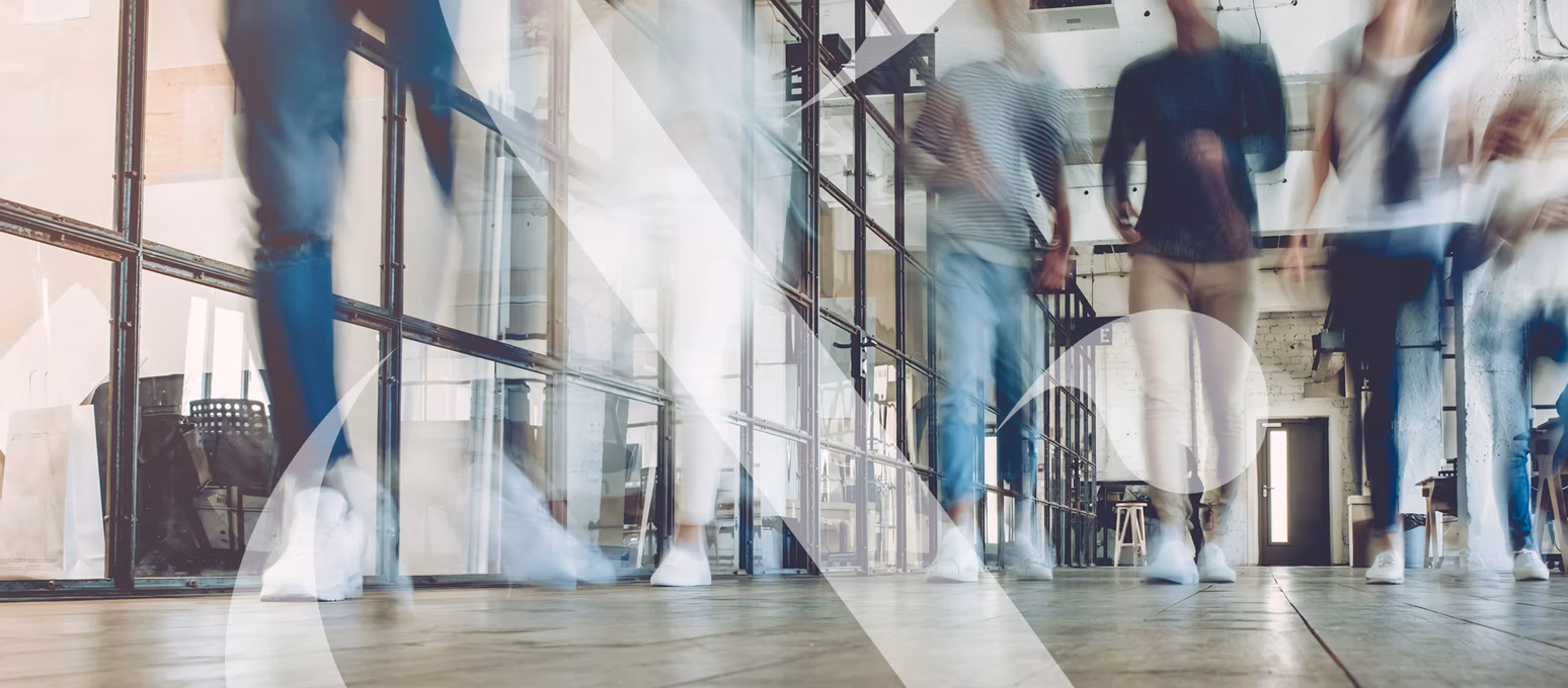 An image taken at floor level showing students walking down a hallway, their motions blurred to show movement.