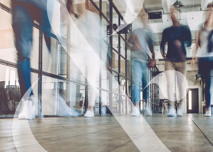 An image taken at floor level showing students walking down a hallway, their motions blurred to show movement.