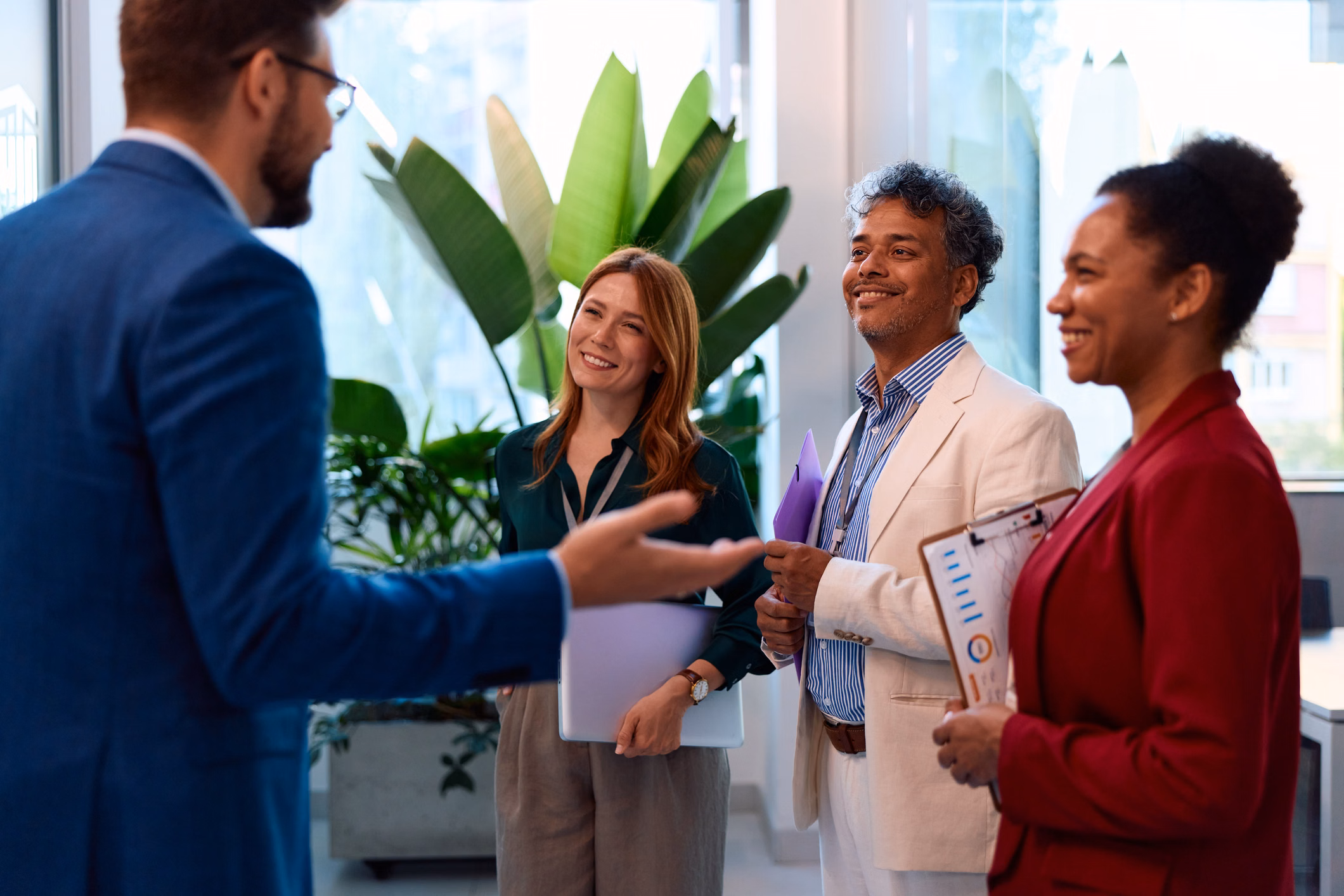 Diverse business professionals having a conversation in a modern office, collaborating and sharing ideas during a casual meeting